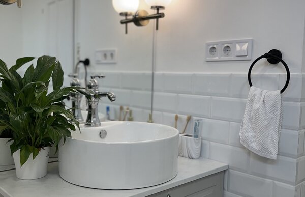 Bagno wellness con lavabo, specchio e luci a parete
