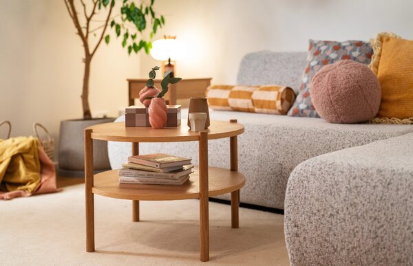 Tavolino rotondo in legno con ripiano accanto al divano