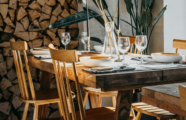 Tavolo da pranzo in legno massello pesante accanto a una catasta di legna