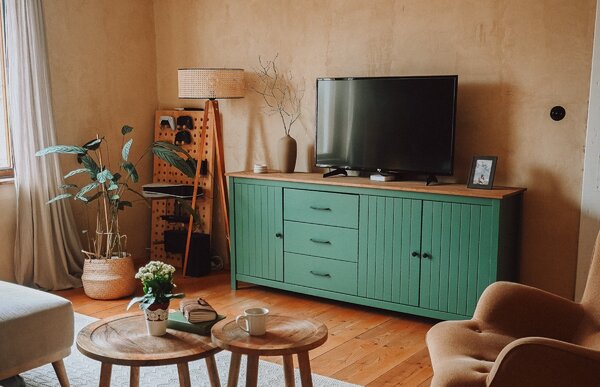 Soggiorno mediterraneo moderno con pareti a calce e credenza in legno