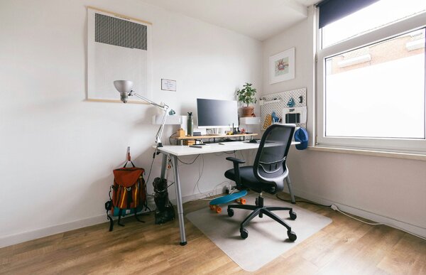 Postazione di lavoro ergonomica in casa con sedia in rete