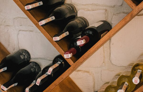 Bottiglie di vino su rastrelliera in tavernetta in mattoni a vista