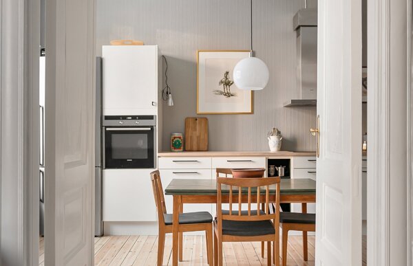 Cucina luminosa con pavimento chiaro e tavolo in legno
