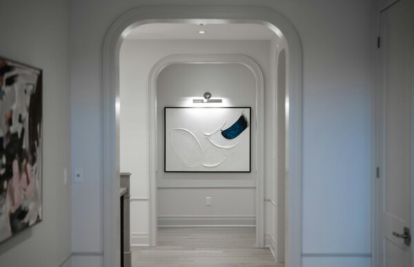 Illuminazione wall-washer su parete chiara con quadri