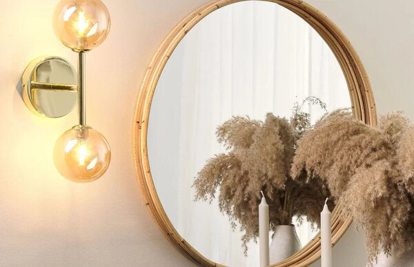 Specchio rotondo e applique che riflettono la luce nell'ambiente