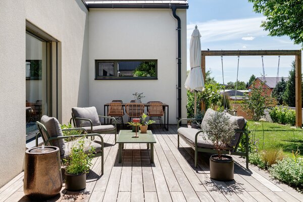 Terrazza in legno con divano da giardino e vista sul verde