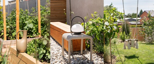 Aiuola rialzata, panca e altalena nel giardino di Eva