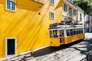 Fotografia Yellow tram moving past yellow building, Alexander Spatari