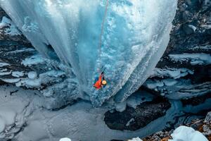Fotografia artistica A woman ice climbs up a, Alex Ratson, (40 x 26.7 cm)