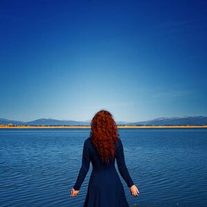 Fotografia artistica Redhead in blue dress faces rippled lake, Anna Gorin, (40 x 40 cm)