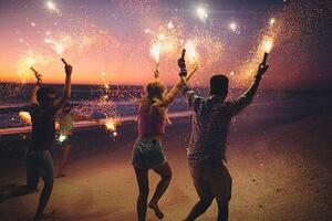 Fotografia Friends running on a beach with fireworks, wundervisuals, (40 x 26.7 cm)