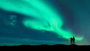 Fotografia Aurora borealis and silhouette of man and woman, den-belitsky