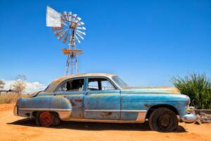 Illustrazione Abandoned vintage car in the desert, Bim