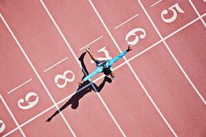 Fotografia Runner crossing finishing line on track, Paul Bradbury