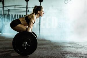 Fotografia Side view of athletic woman exercising, skynesher