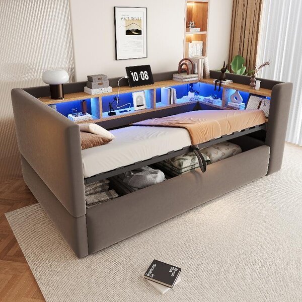 Divano letto 90x190 cm di colore grigio scuro, dotato di vano contenitore idraulico, illuminazione a LED, presa di corrente e ripiani portaoggetti, con struttura imbottita per un comodo utilizzo come letto singolo