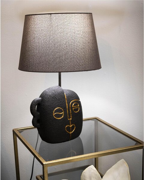 Lampada da tavolo in resina dalla forma ispirata ad un volto tribale Dimensioni 30,5xh 46 cm in resina e paralume in tessuto grigio