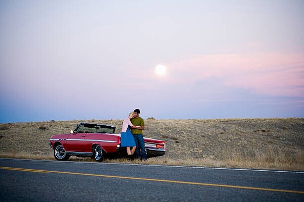 Fotografia artistica man and woman next to a red convertible, Mike Kemp, (40 x 26.7 cm)