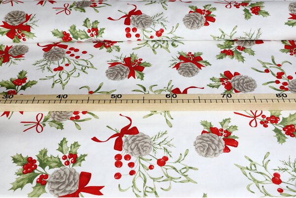 Tessuto decorativo natalizio in cotone con pigne, agrifoglio e fiocchi rossi su sfondo bianco