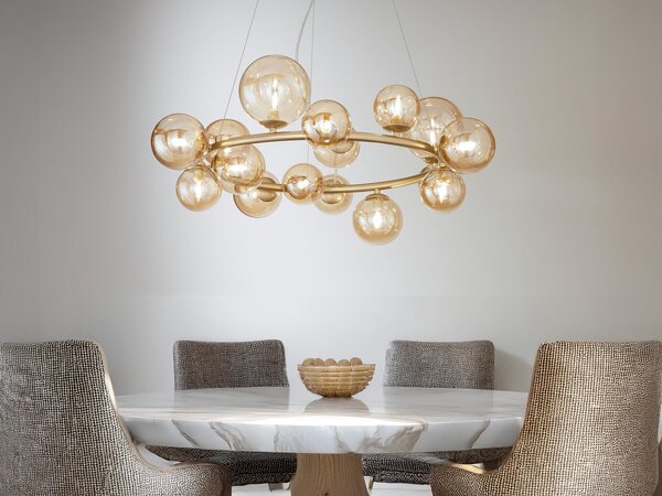 Grande e insolita lampada a sospensione a LED, con globi in vetro e oro a più fiamme, sul tavolo da pranzo