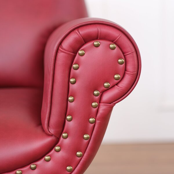 Poltrona design vintage Vico pelle fiore pull up rosso ciliegia con borchie anticate e gambe nere e ottone